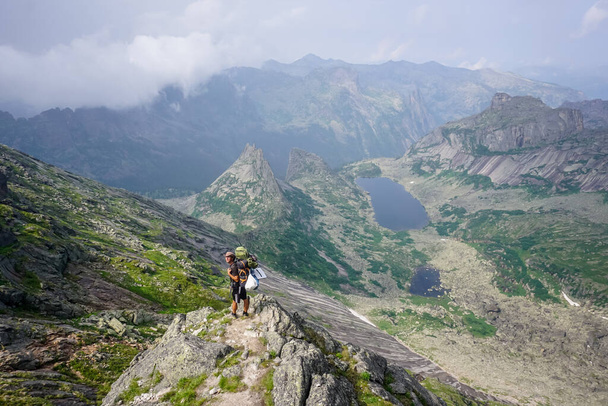 Natural Park Ergaki, Russia - July 15, 2019: Traveler on nature in the mountains - Foto, afbeelding