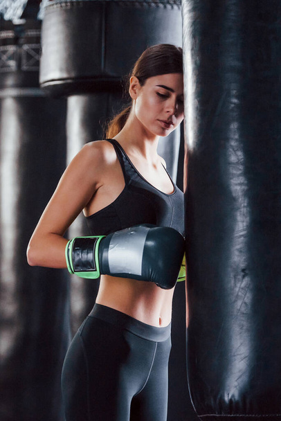 Young woman in sportive wear is in the gym having exercise day. Conception of boxing. - Foto, afbeelding