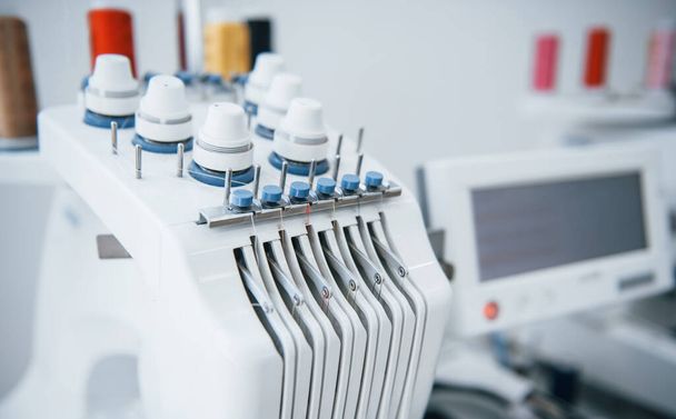 Close up view of white automatic sewing machine at factory. - Valokuva, kuva