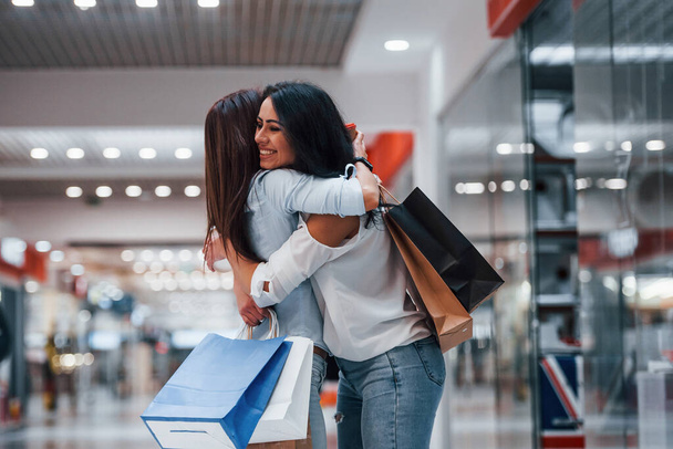 Meeting of two female friends in the mall at weekend shopping time. - Foto, Bild