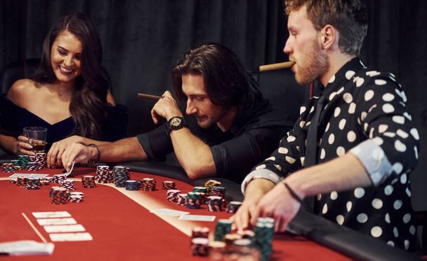 Group of elegant young people that playing poker in casino together. - Фото, зображення