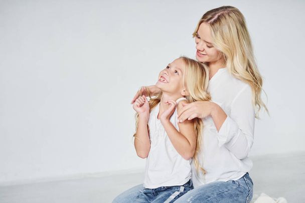 Closeness of the people. Mother with her daughter together in the studio with white background. - Foto, Bild