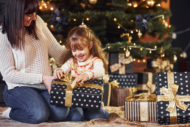 Mother with her little daughter celebrating christmas with presents. - Fotografie, Obrázek