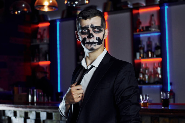 Portrait of man that is on the thematic halloween party in scary skeleton makeup and costume. - Fotó, kép
