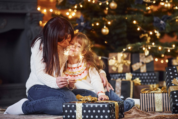 Mother with her little daughter celebrating christmas with presents. - Foto, imagen