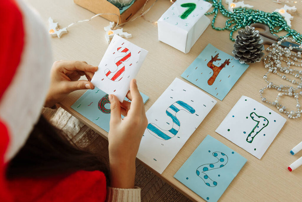 a child makes a Christmas advent calendar out of paper with his own hands diy close up - Fotoğraf, Görsel