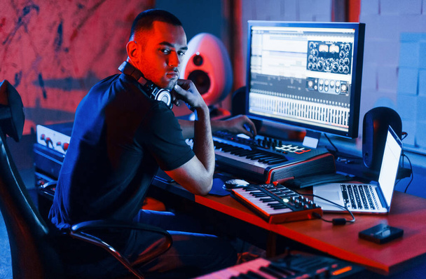 Guy have a job with project and mixing music indoors in the studio. - Foto, Bild