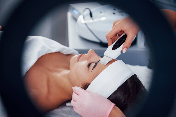 Using special device. Close up view of woman that lying down in spa salon and have face cleaning procedure. - Photo, Image
