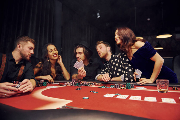 Group of elegant young people that playing poker in casino together. - Photo, Image