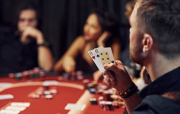 Group of elegant young people that playing poker in casino together. - 写真・画像
