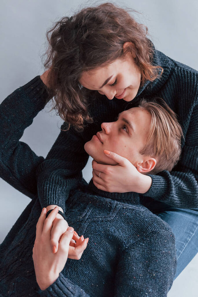 Cute young couple embracing each other indoors in the studio. - Fotó, kép
