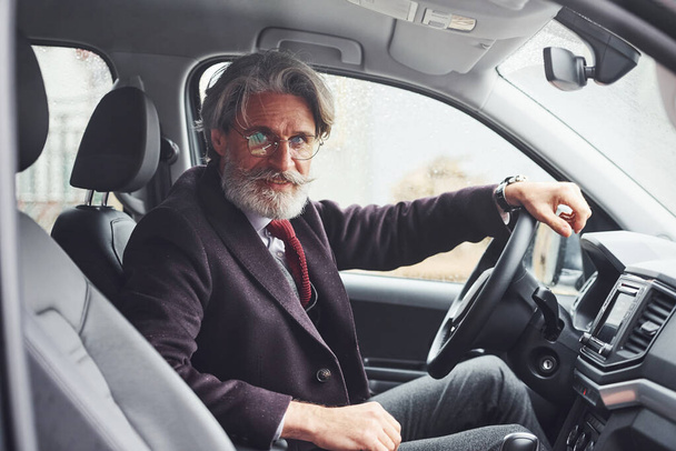 Fashionable senior man in elegant clothes is in the modern car. - Fotoğraf, Görsel