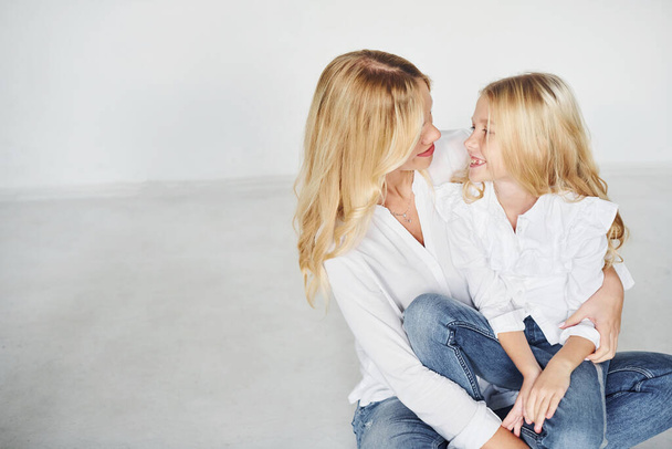 Mother with her daughter have fun together in the studio with white background. - Foto, afbeelding