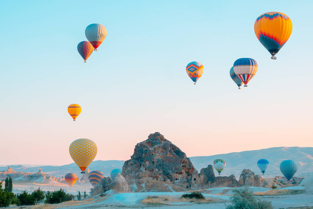 Hot air balloons and fairy chimneys in Cappadocia Turkey. Cappadocia background photo. Hot air balloon activity in Goreme.  - Foto, afbeelding