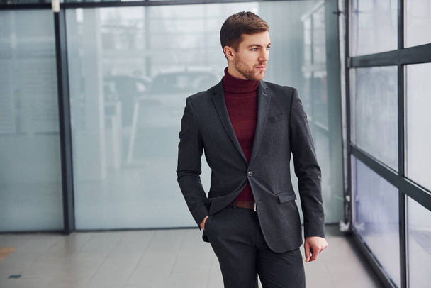 Young business man in luxury suit and formal clothes is indoors in the office. - Foto, imagen
