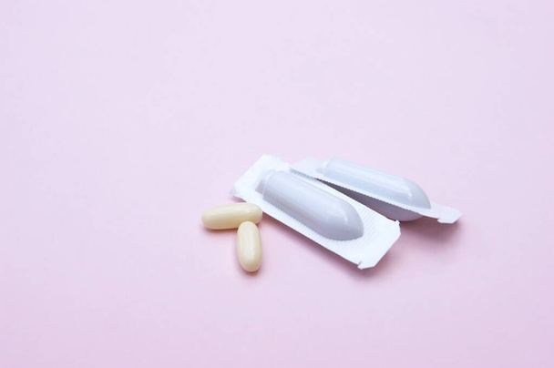 Gynecological medicines for women's health in form of suppository, capsules on pink background. Vulvovaginal infections treatment. - Photo, Image