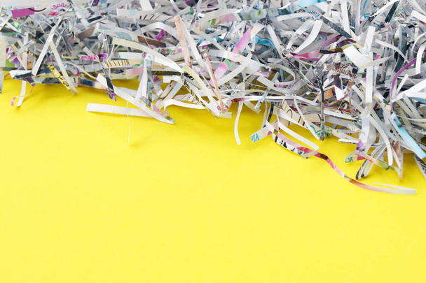 Shredded paper on light yellow background. Selective focus image. - Photo, Image