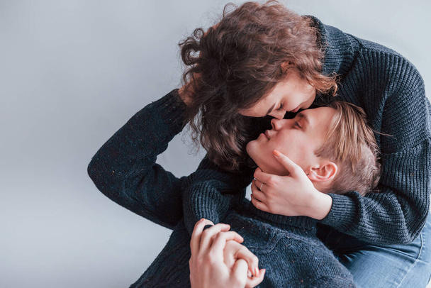 Cute young couple kissing each other indoors in the studio. - Foto, Bild