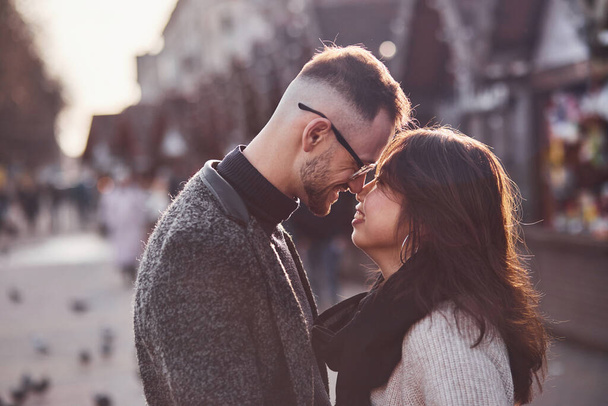 Happy multiracial couple together outdoors in the city. Asian girl with her caucasian boyfriend. - Фото, изображение