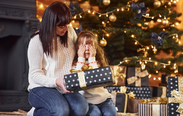 Mother with her little daughter celebrating christmas with presents. - Foto, imagen