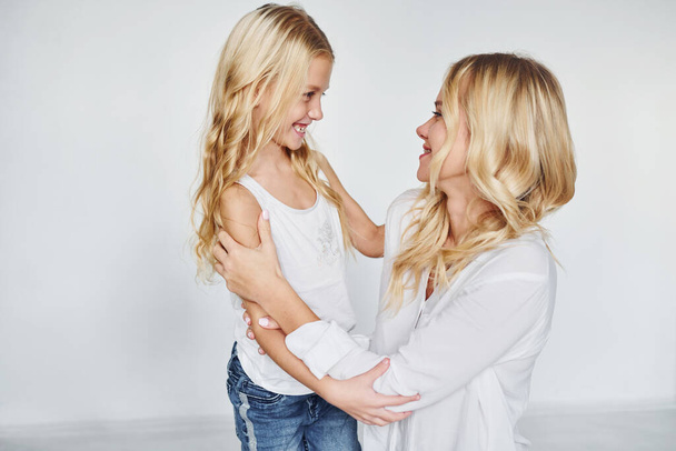 Mother with her daughter have fun together in the studio with white background. - Foto, Imagen