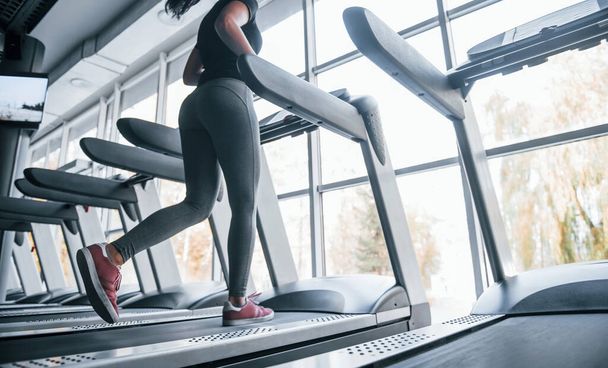 Young girl in sportive clothes running on treadmill in the gym. - Foto, immagini