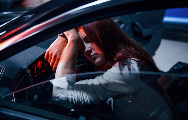 Young woman is inside of brand new modern automobile and sleeping. - 写真・画像