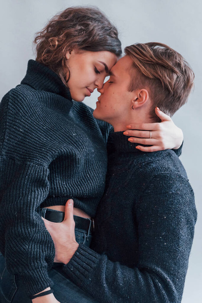 Cute young couple kissing each other indoors in the studio. - Fotoğraf, Görsel