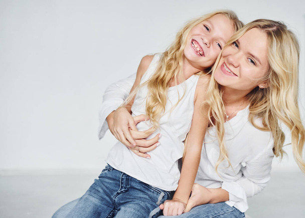 Closeness of the people. Mother with her daughter together in the studio with white background. - Fotoğraf, Görsel