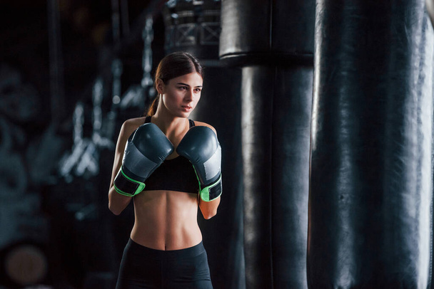 Young woman in sportive wear is in the gym having exercise day. Conception of boxing. - Photo, image
