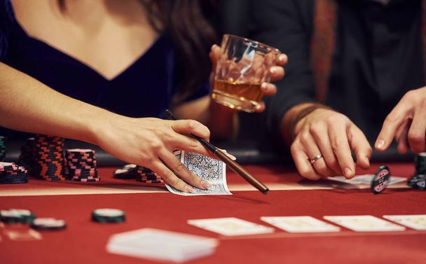 Close up view of elegant young people's hands that playing poker in casino. - 写真・画像