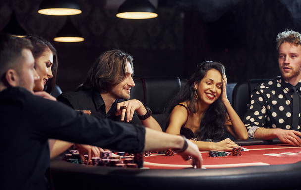 Group of elegant young people that playing poker in casino together. - Foto, Imagem