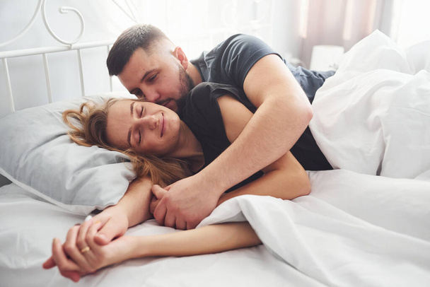 Cute young couple lying down on the bed and sleeping together. - Fotografie, Obrázek