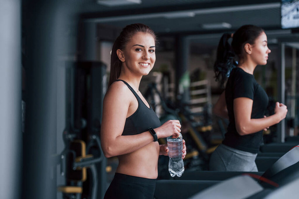 Two young girls in sportive clothes is in the gym together at treadmill. - Foto, Imagem