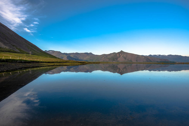 vuoret heijastuvat leppoisissa vesissä laavapeltojen ympärillä, jotka risteävät tien varrella Snaefellsnesin niemimaalla Islannissa - Valokuva, kuva