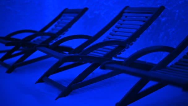 Стулья для отдыха в соляной комнате с голубым светом - Кадры, видео