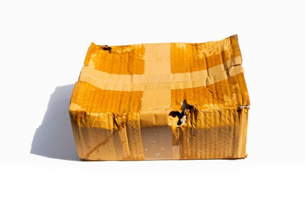 Damaged cardboard box with hole, Broken and wet product packaging - Foto, afbeelding
