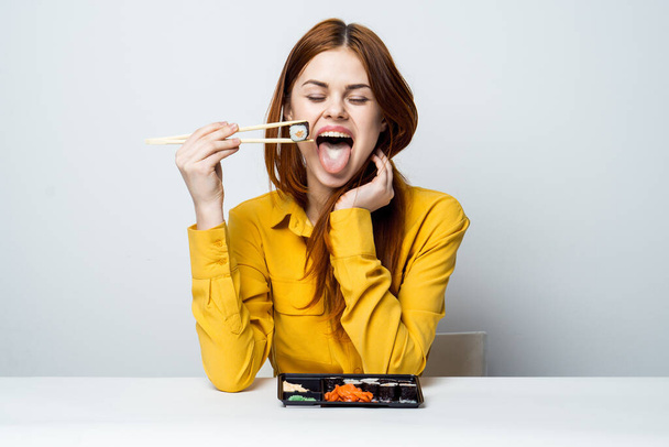 woman at the table eating sushi restaurant japanese snack - Фото, изображение