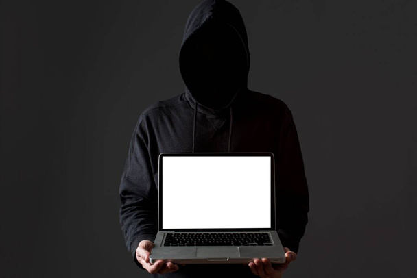 フロントビュー男性ハッカーがノートパソコンを持ってる。高品質の写真 - 写真・画像
