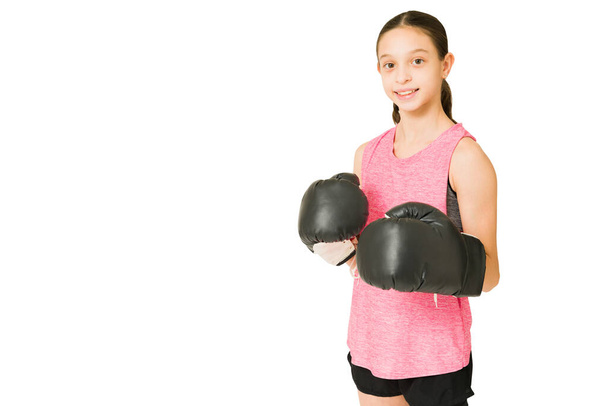 Happy caucasian preteen with black boxing gloves ready to do some training and workout - Photo, Image