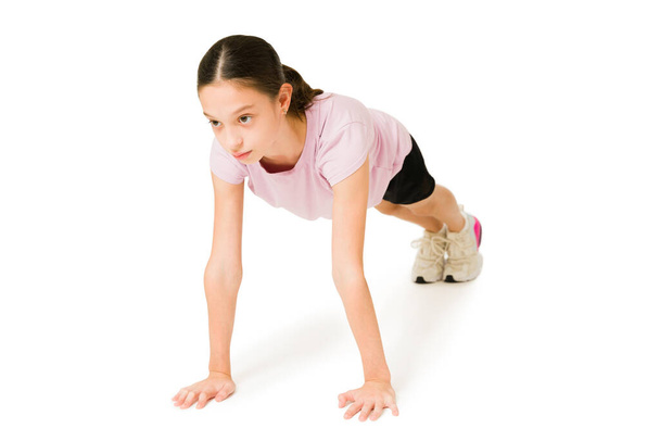 Kuntoilumaaleja. Urheilullinen pieni tyttö laskee hänen push ups aikana hänen workout rutiini  - Valokuva, kuva