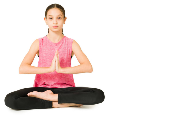 Relaxed caucasian young girl in a prayer position and doing breathing exercises during a meditation - Фото, изображение