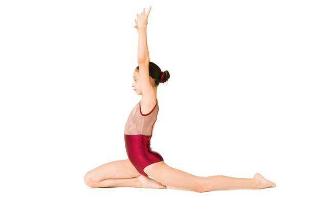 Profiel van een jong meisje met veel flexibiliteitstraining tijdens haar gymnastieklessen  - Foto, afbeelding
