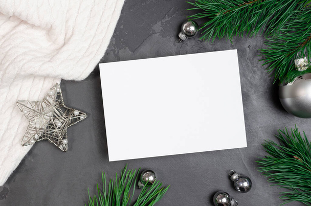 Christmas greeting card mockup with silver festive decorations and pine tree branches on dark background - Foto, immagini