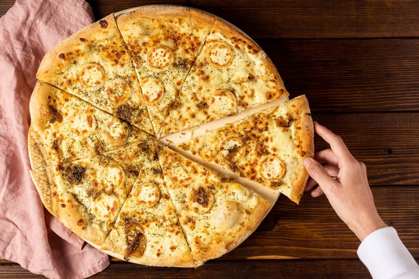 górny widok strony biorąc kawałek sera do pizzy. Wysokiej jakości zdjęcie - Zdjęcie, obraz
