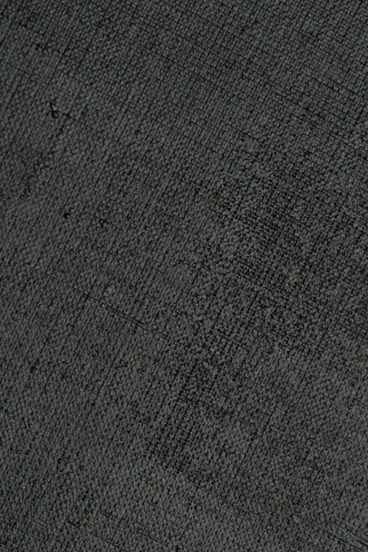 sfondo creativo scuro: tela di lino innescata nera, illuminazione irregolare, tonificante  - Foto, immagini