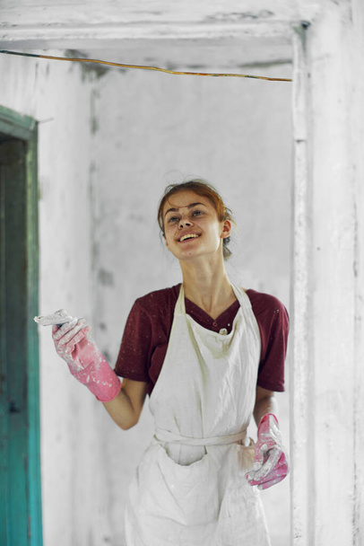 cheerful woman painter In a white apron home renovation - Фото, изображение