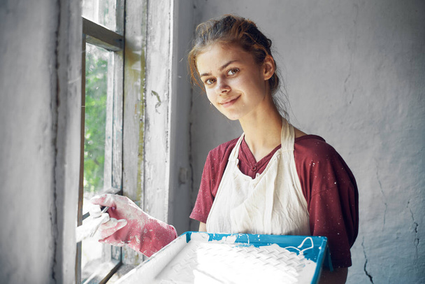 woman in apron painter repair painting window - Φωτογραφία, εικόνα