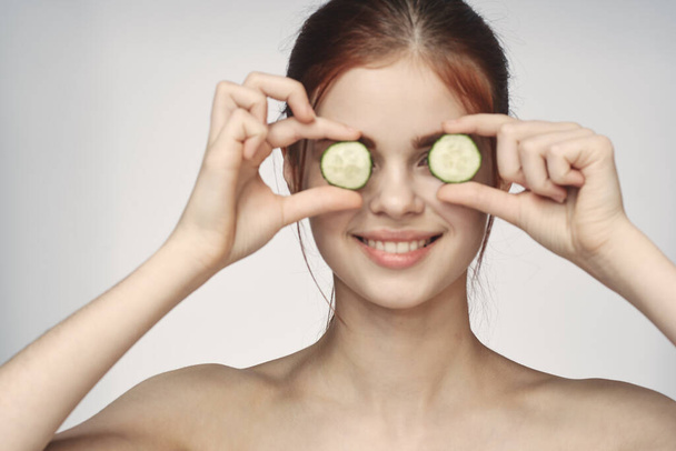 cheerful woman with cucumbers bare shoulders skin care cosmetology - Valokuva, kuva