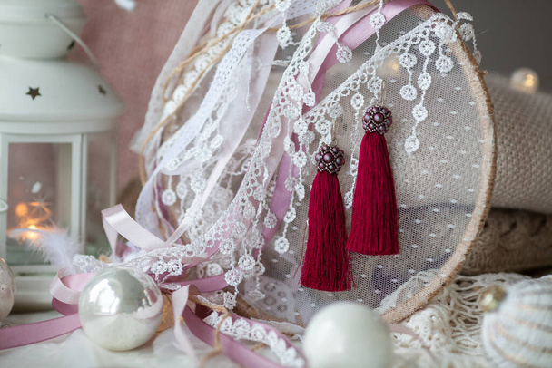 StyliStylish beautiful tassel earrings on lace. Fashionable accessory for the holiday.sh beautiful tassel earrings on lace. Fashionable accessory for the holiday. - Foto, Imagen